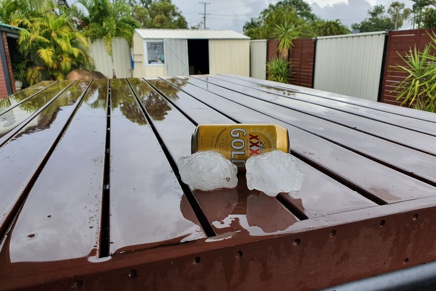 Two hailstones in front of a can of beer. 