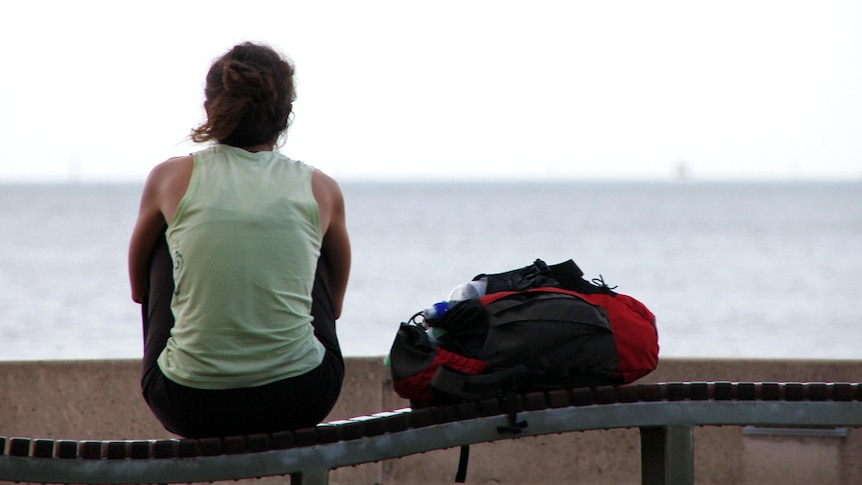 Backpacker looks out to the ocean