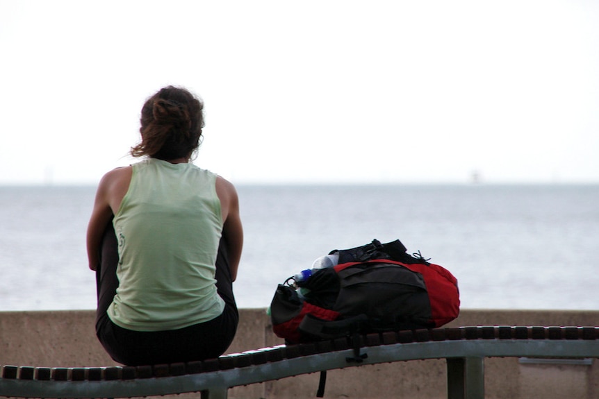 Backpacker looks out to the ocean