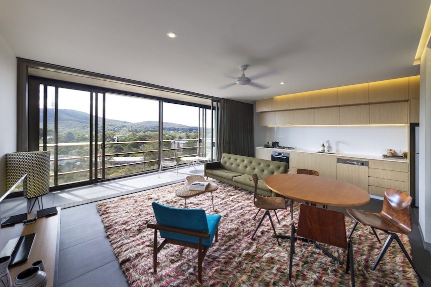 View of apartment loungeroom and kitchen with windows overlooking Black Mountain Tower.