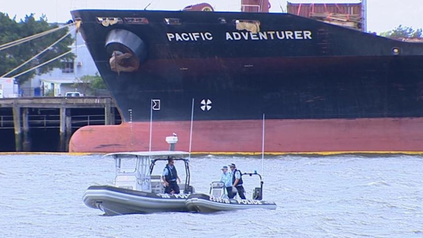 TV still of damaged cargo ship Pacific Adventurer in Brisbane with two Qld police boats in water