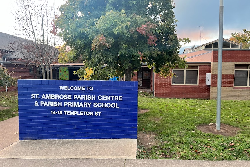 a picture of the exterior of the school and a sign 'st ambrose parish centre primary school'