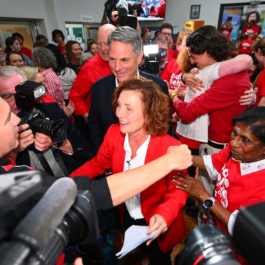 Jodie Belyea and Richard Marles celebrating in a group of people wearing red. 