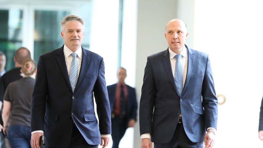 Peter Dutton and Mathias Cormann walk down a  parliament hall