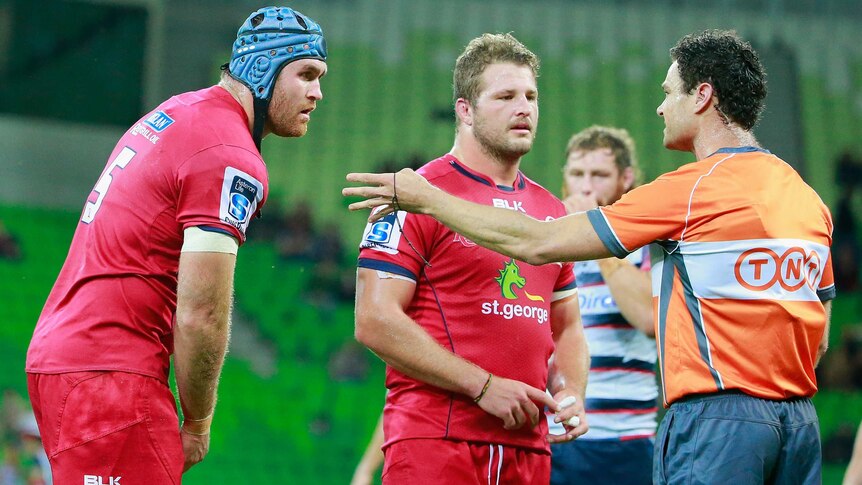 The Reds' James Horwill is sent off by referee Matt O'Brien as captain James Slipper looks on.