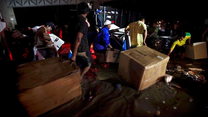 Looters carry goods through a flooded street in Acapulco.