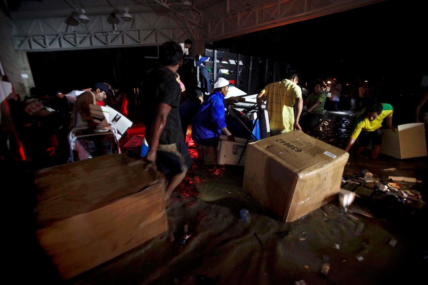 Looters carry goods through a flooded street in Acapulco.