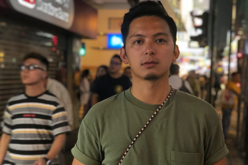 Mixe Lee poses for a photo in amongst shops and people in Hong Kong.