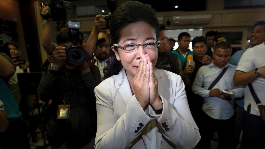 Pheu Thai party leader Sudarat Keyuraphan presses her palms together in a traditional Thai greeting.