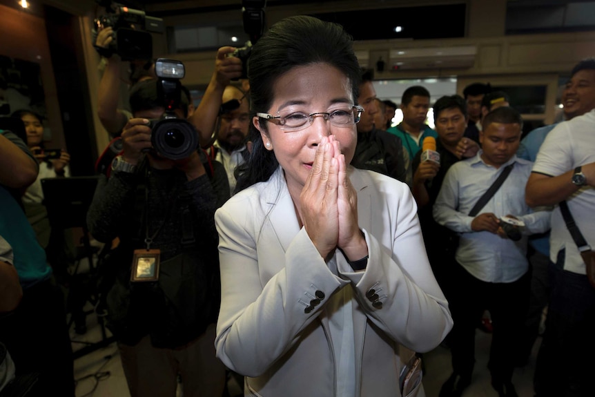 Pheu Thai party leader Sudarat Keyuraphan presses her palms together in a traditional Thai greeting.