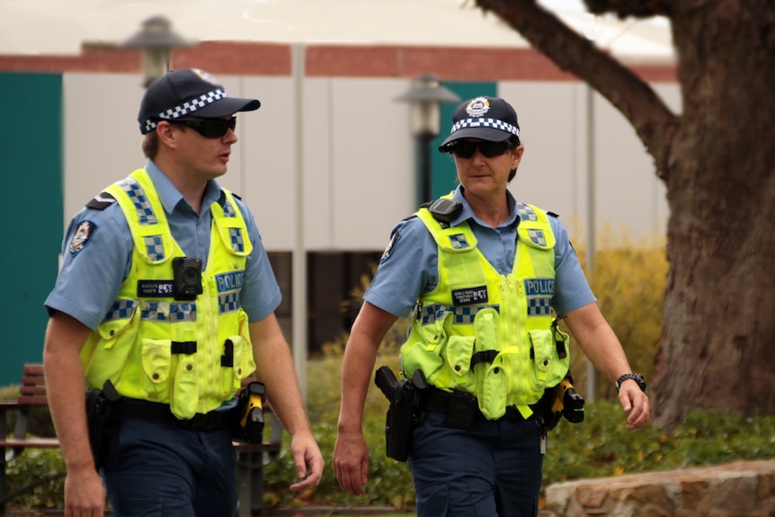 Two police offices walking through a park