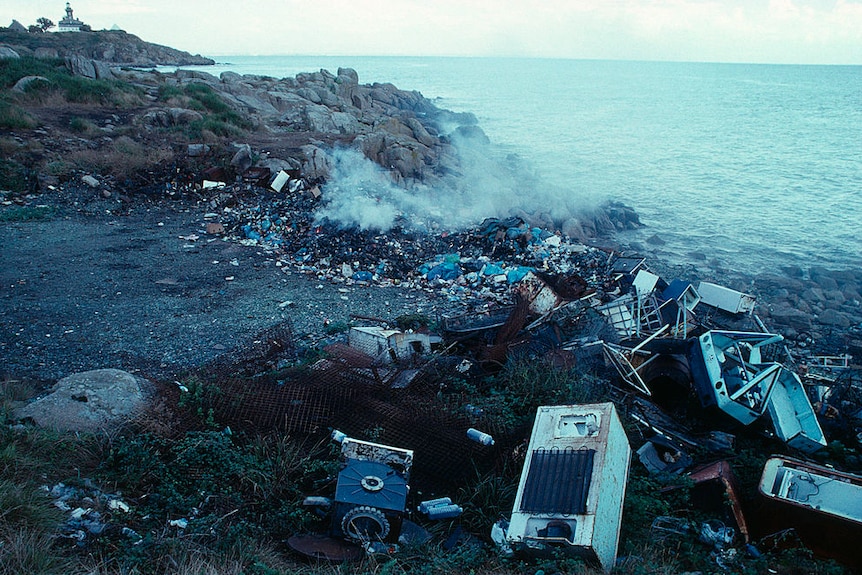 Old fridges on a shoreline.