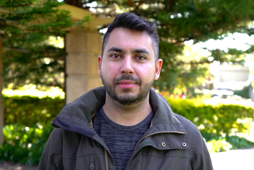 head and shoulders shot of man standing looking into camera 