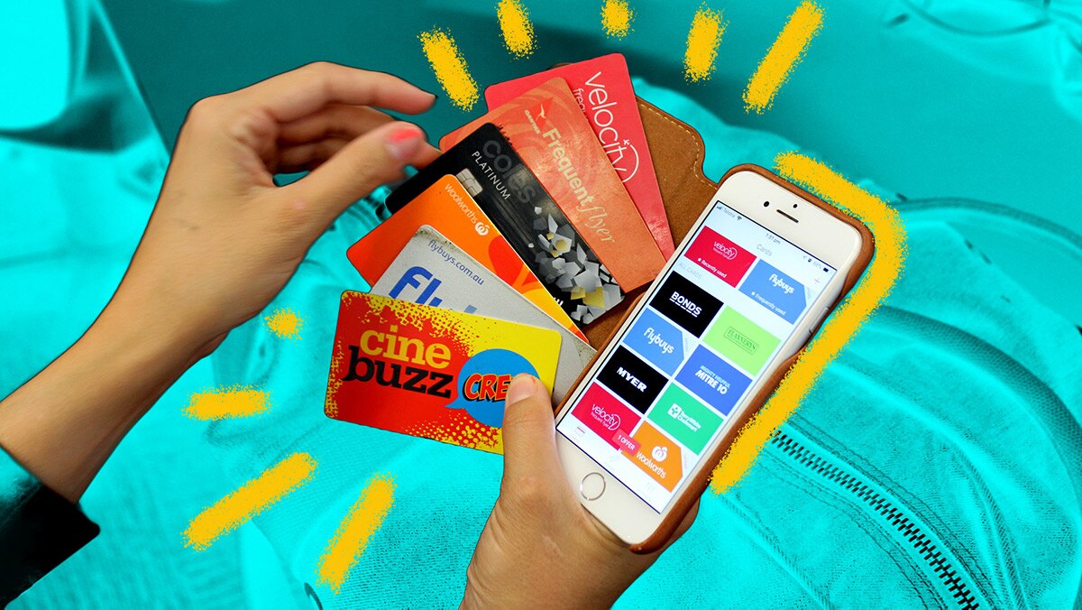 Woman holds credit and rewards cards and a phone with a reward cards app on the screen for a story about loyalty programs.