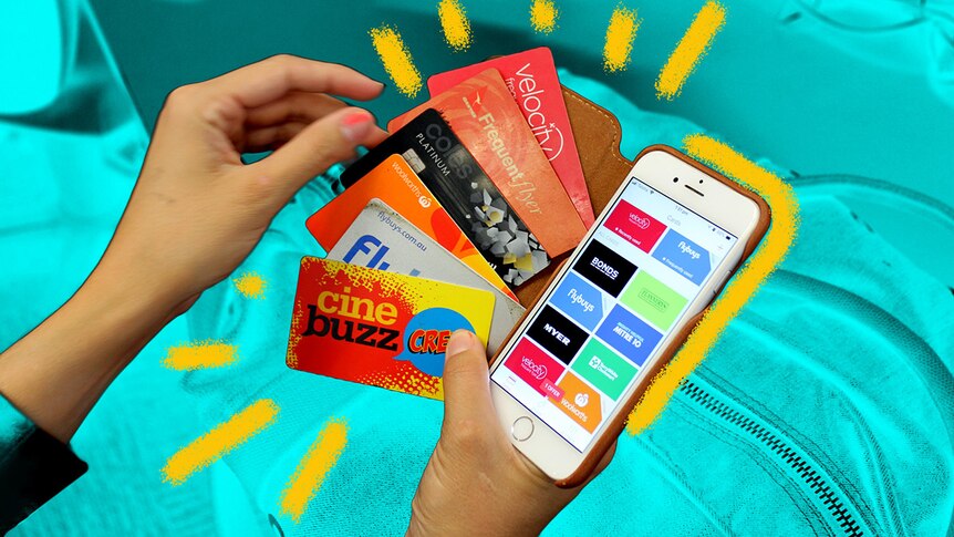 Woman holds credit and rewards cards and a phone with a reward cards app on the screen for a story about loyalty programs.