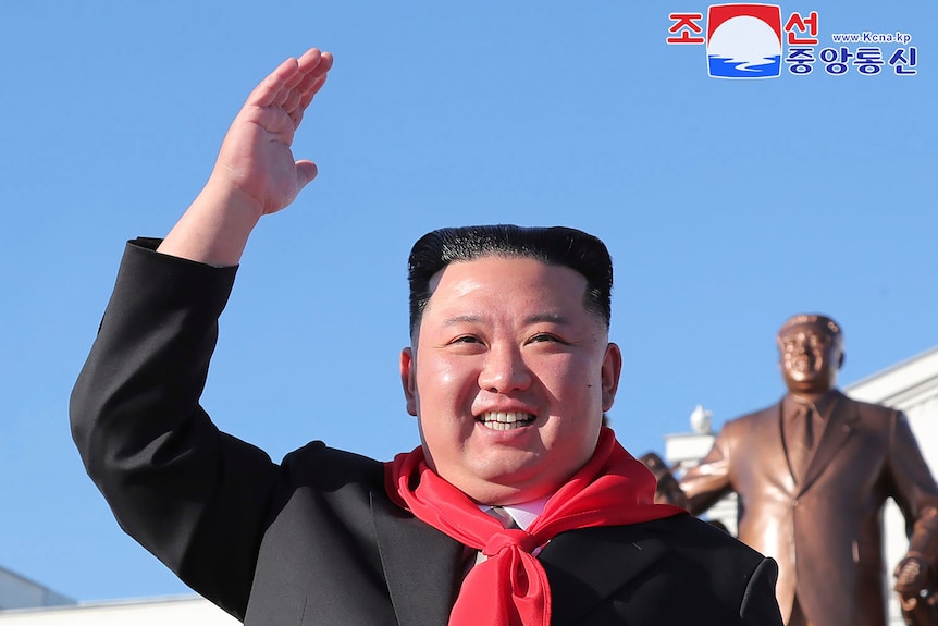 Kim Jong Un waves.