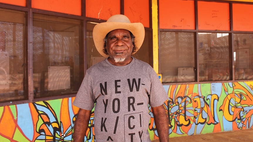 Otto Sims stands outside the centre, wearing an Akubra and a t-shirt that says "New York City".