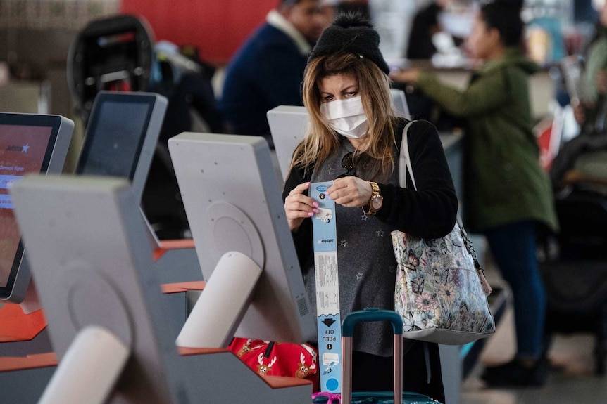 a woman using a self check in machine at an airport