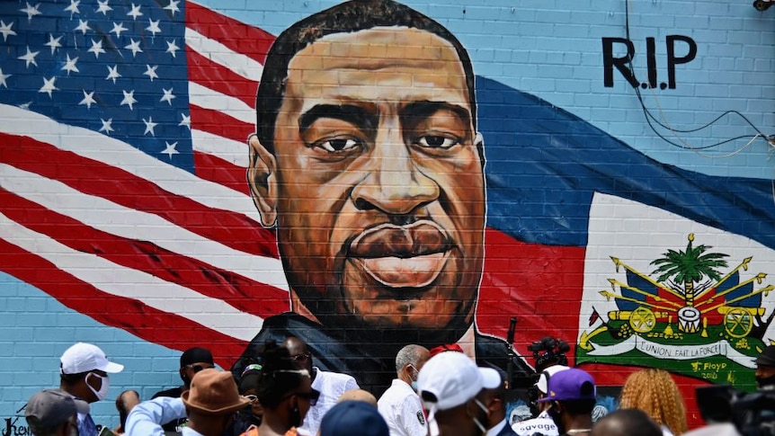 People gather at the unveiling of artist Kenny Altidor's memorial portrait of George Floyd.