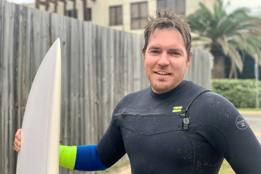 Stephen Wheatley with his surfboard.