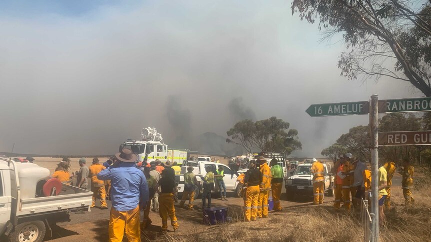 Volunteer fire fighters standing on busy road
