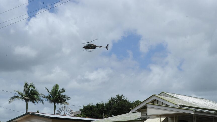 Two Australian Defence Force helicopters fly over the devastated township of Grantham