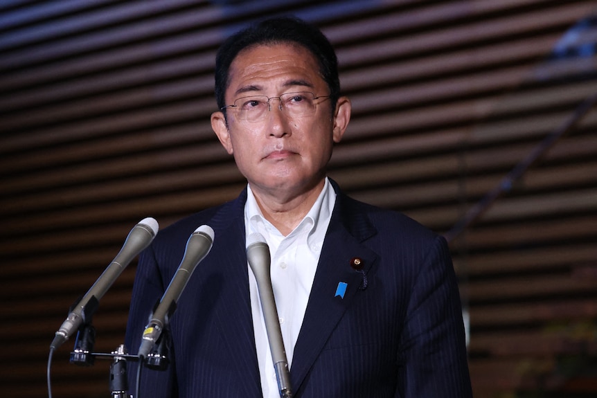 Fumio Kishida in a suit and glasses speaks to media at a press conference in Tokyo