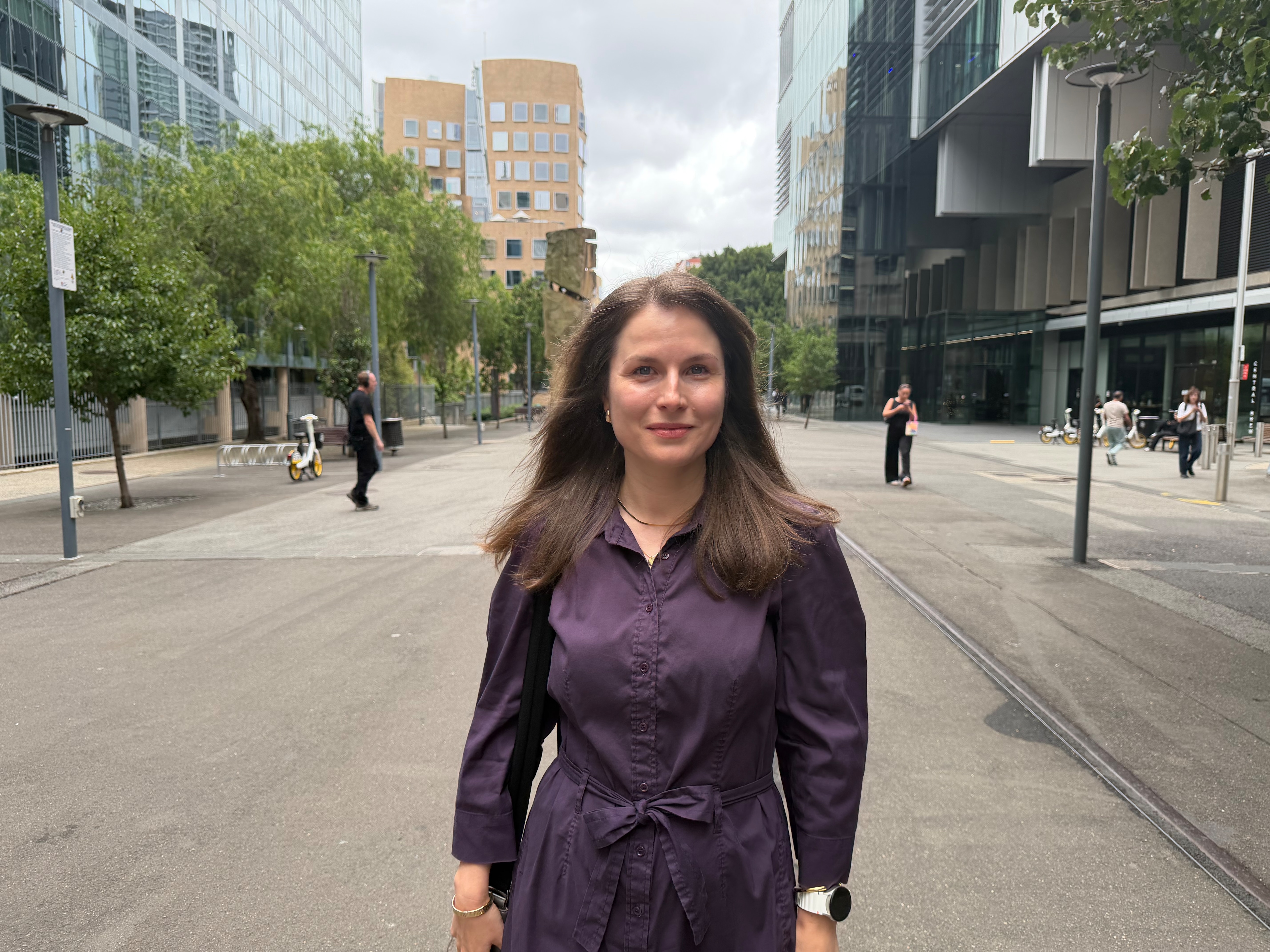 Uma mulher posa com um vestido roxo