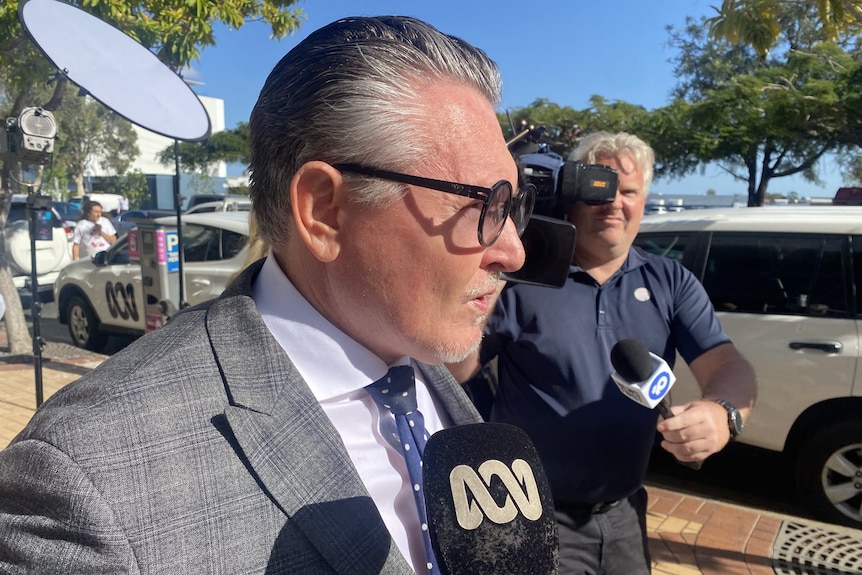 A man in glasses being interviewed outside court.