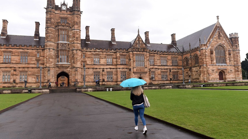 A student walks toward the quadrangle at the University of Sydney
