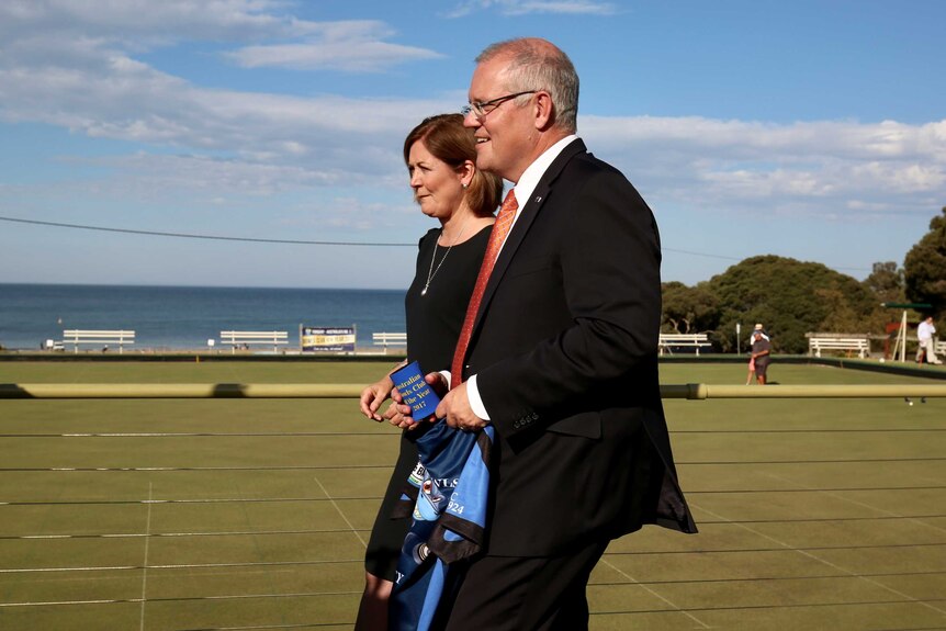 Scott Morrison and Sarah Henderson stand on a bowling green