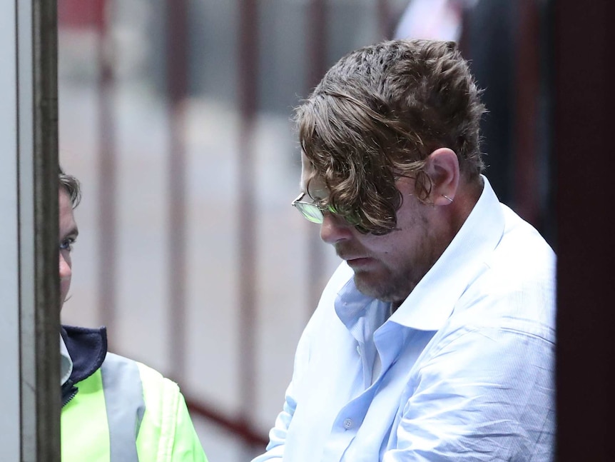 Jason Considine leaves the Supreme Court of Victoria in Melbourne flanked by an officer.