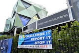 A banner with a message 'Challenge It Report It Stop It, Leeds No Place For Hate' hangs outside a cricket ground.