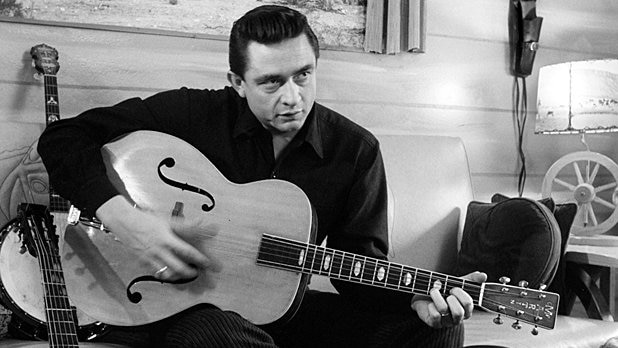 Johnny Cash holds his guitar.
