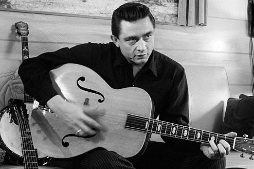 Johnny Cash holds his guitar.