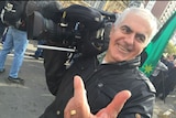 Vince Tucci holding camera while covering a demonstration.