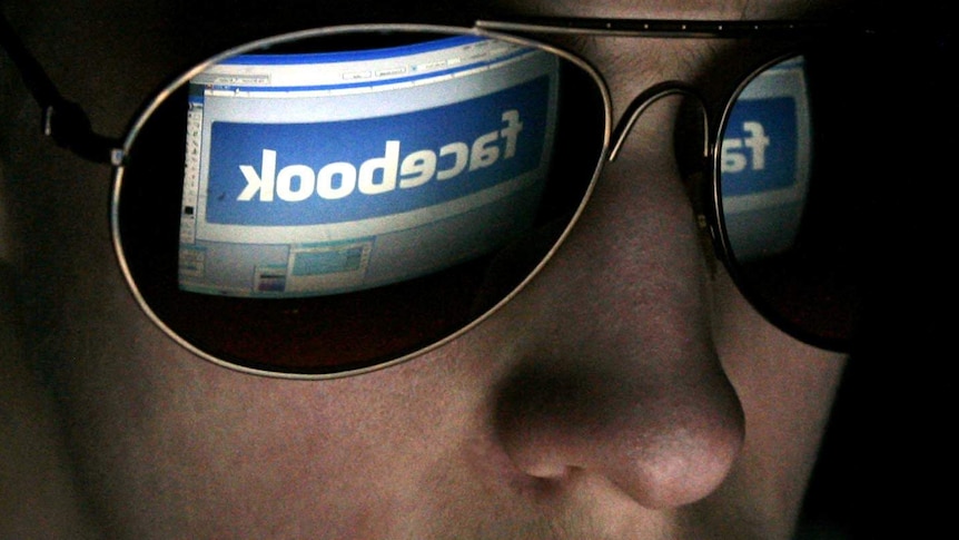 A youth looks at a computer with Facebook logo on it, February 2009.