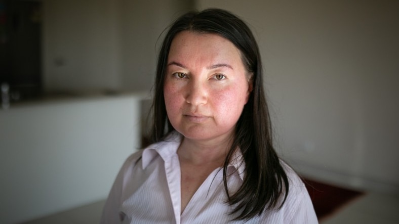 A woman with long brown hair looking solemn