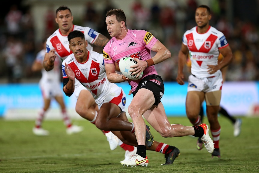 A rugby league player runs the ball during a match 