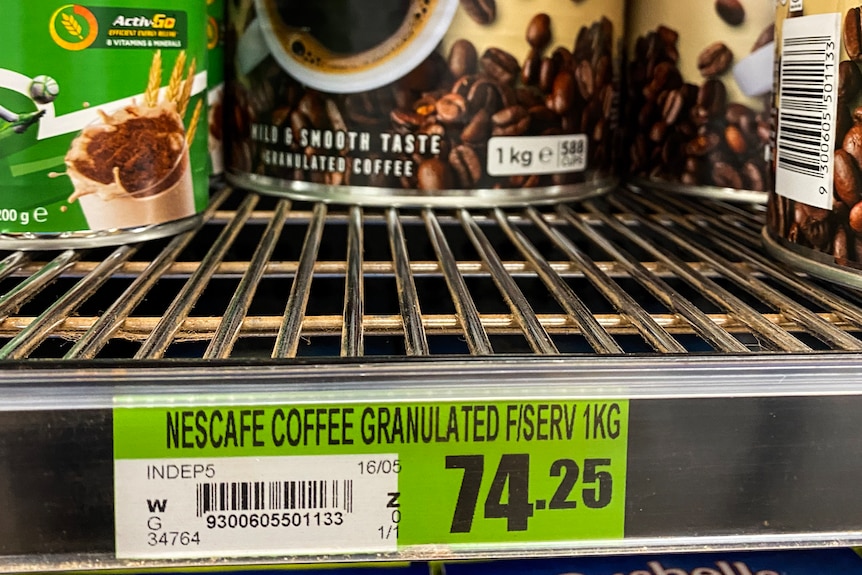 A sign in a supermarket that says the price of coffee is $74. 