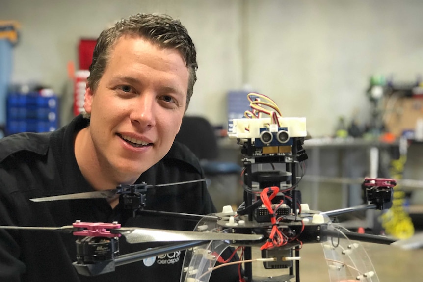 Man staring at camera, holding a drone