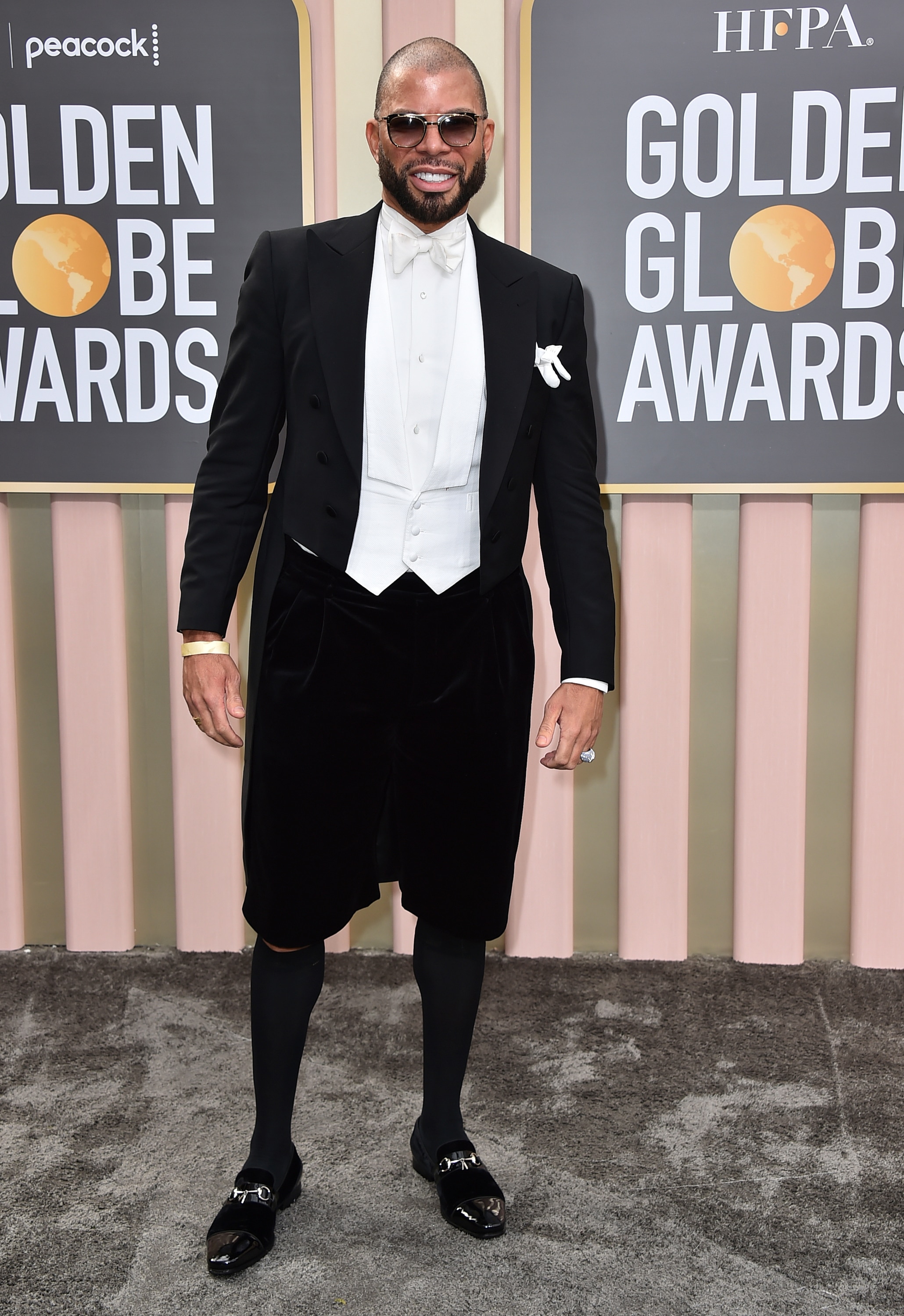 Al Reynolds wearing a black suit jacket with black shorts, high-knee socks and loafers. 