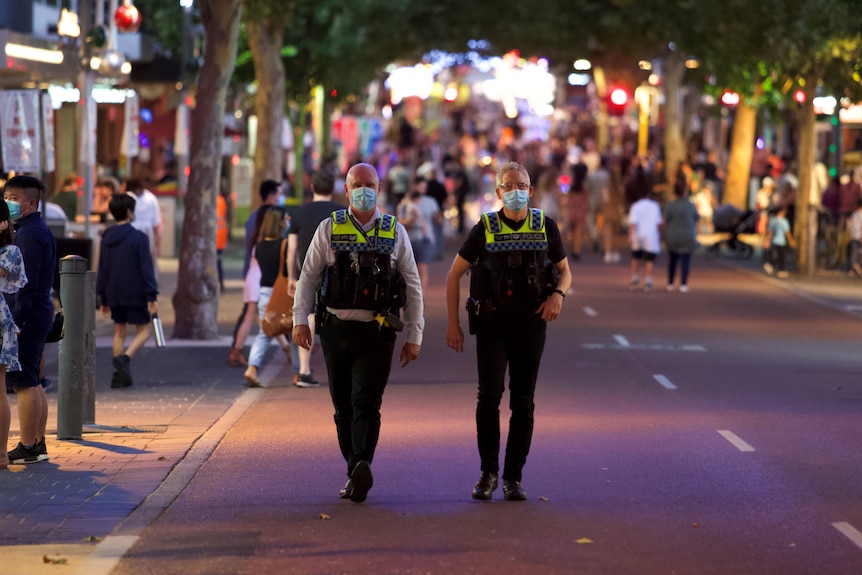 Police officers in masks walking through Northbridge.