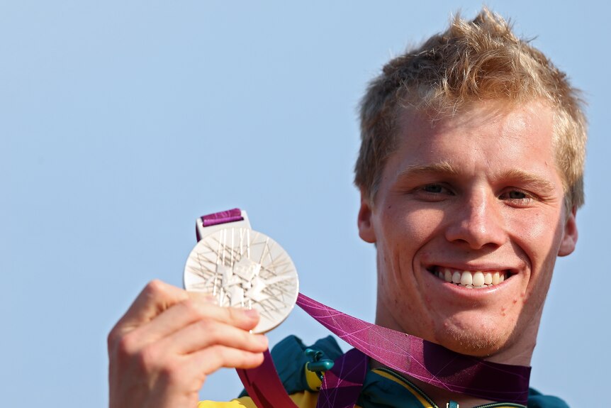 Sam Willoughby holds his silver medal and smiles