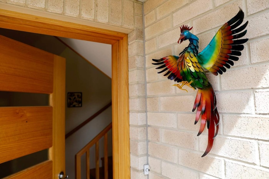 A phoenix statue next to the front door.