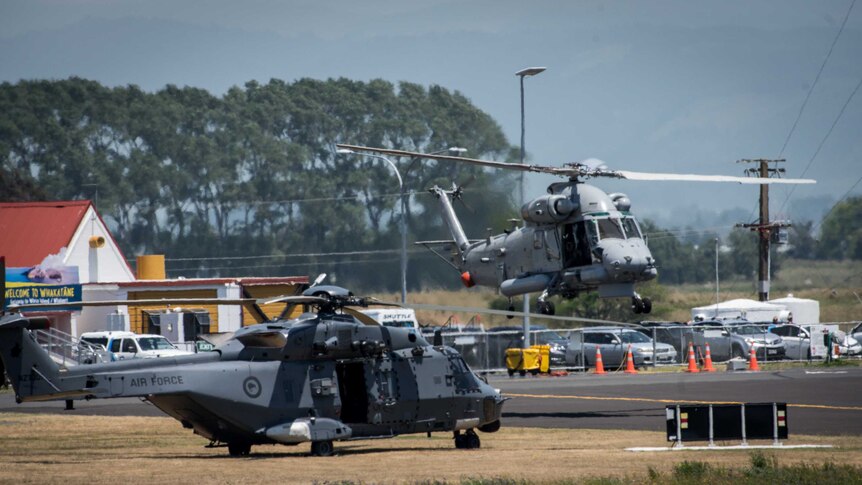 A helicopter lands next to another helicopter