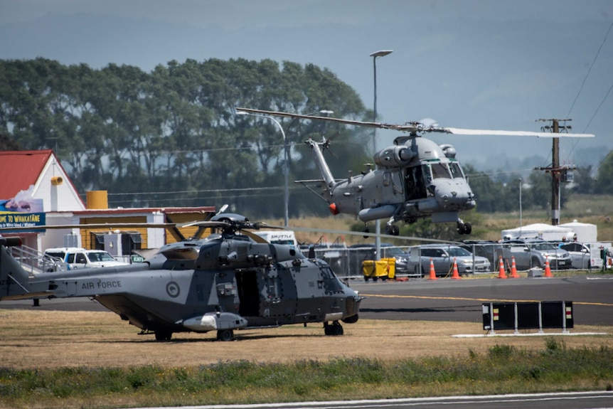 A helicopter lands next to another helicopter