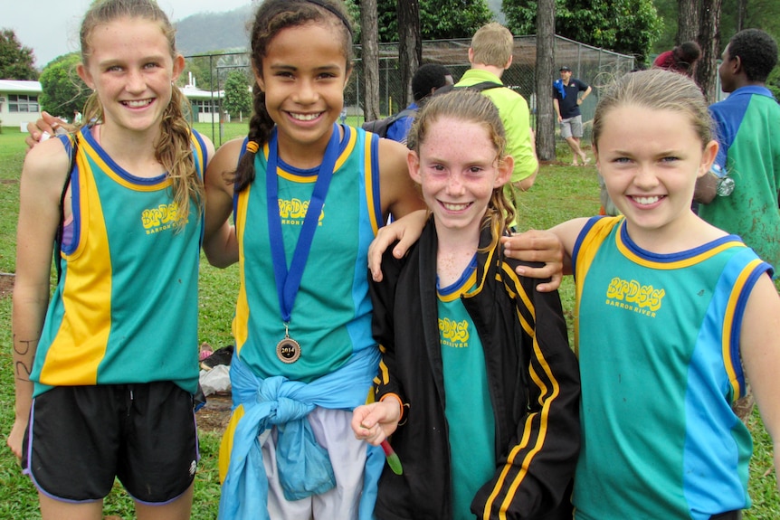 Four girls with medals posing.