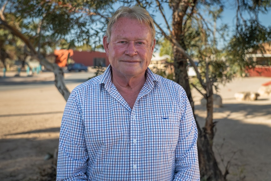 David White standing in front of a small tree 