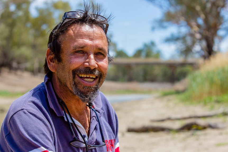 A man in front of a dry river bed